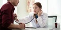 Female doctor asian cardiologist examining senior male cardiac patient listening checking heartbeat using stethoscope at Royalty Free Stock Photo