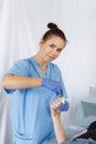 A female doctor beautician makes a procedure shugaring on the fingers of the right hand woman to the patient. Vertical