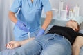 A female doctor beautician makes a procedure shugaring on the right arm of a woman to the patient.