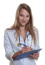 Female doctor with blond hair and clipboard Royalty Free Stock Photo