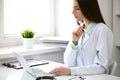 Female doctor brunette sitting at the table near the window in hospital Royalty Free Stock Photo