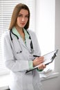 Female doctor brunette sitting at the table near the window in hospital Royalty Free Stock Photo