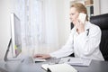 Female Doctor Calling Phone While Using Computer Royalty Free Stock Photo