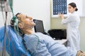 Female doctor carrying out electroencephalography of man