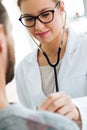 Female doctor checking patient heartbeat using stethoscope. Royalty Free Stock Photo