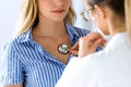 Female doctor checking patient heartbeat using stethoscope. Royalty Free Stock Photo