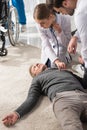female doctor checking unconscious middle aged man