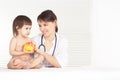 Female Doctor with child. Girl holding apple Royalty Free Stock Photo
