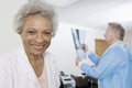 Female Doctor With Colleague Examining X-Ray In Background Royalty Free Stock Photo