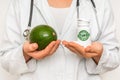 Female doctor compare pile of pills with fresh avocado