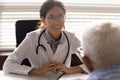 Female doctor consult old male patient in hospital Royalty Free Stock Photo