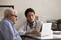 Female doctor consult senior male patient using computer Royalty Free Stock Photo
