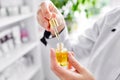 A female doctor-cosmetologist holds a bottle of argan oil