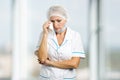 Female doctor crying, blurred background.