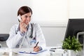 Female doctor at desk with telephone Royalty Free Stock Photo