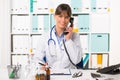 Female doctor at desk with telephone Royalty Free Stock Photo