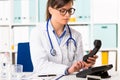 Female doctor dialling number on telephone