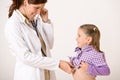 Female doctor examining child with stetoscope