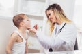 Female doctor examining child with tongue depressor Royalty Free Stock Photo