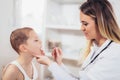 Female doctor examining child with tongue depressor Royalty Free Stock Photo