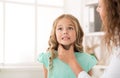 Female doctor examining girl tonsils in hospital