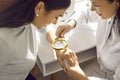 Female doctor examining hand skin of a young woman patient using magnifying glass. Royalty Free Stock Photo