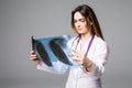 Female doctor examining an x-ray image. Focus is on the x-ray image on grey background. Royalty Free Stock Photo