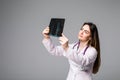 Female doctor examining an x-ray image. Focus is on the x-ray image isolated on grey background. Royalty Free Stock Photo