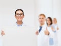 Female doctor in eyeglasses with white blank board Royalty Free Stock Photo