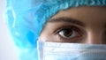 Female doctor in face mask closeup, confident look of professional doctor