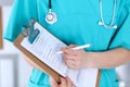 Female doctor filling up medical form on clipboard closeup. Physician finish up examining his patient in hospital an Royalty Free Stock Photo