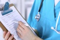 Female doctor filling up medical form on clipboard closeup. Physician finish up examining his patient in hospital an Royalty Free Stock Photo