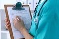 Female doctor filling up medical form on clipboard closeup. Physician finish up examining his patient in hospital an Royalty Free Stock Photo