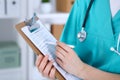 Female doctor filling up medical form on clipboard closeup. Physician finish up examining his patient in hospital an Royalty Free Stock Photo