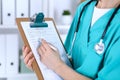 Female doctor filling up medical form on clipboard closeup. Physician finish up examining his patient in hospital an Royalty Free Stock Photo