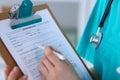 Female doctor filling up medical form on clipboard closeup. Physician finish up examining his patient in hospital an Royalty Free Stock Photo