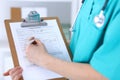 Female doctor filling up medical form on clipboard closeup. Physician finish up examining his patient in hospital an Royalty Free Stock Photo