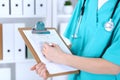 Female doctor filling up medical form on clipboard closeup. Physician finish up examining his patient in hospital an Royalty Free Stock Photo