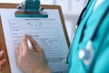 Female doctor filling up medical form on clipboard closeup. Physician finish up examining his patient in hospital an Royalty Free Stock Photo