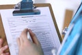 Female doctor filling up medical form on clipboard closeup. Physician finish up examining his patient in hospital an Royalty Free Stock Photo