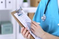 Female doctor filling up medical form on clipboard closeup. Physician finish up examining his patient in hospital an Royalty Free Stock Photo