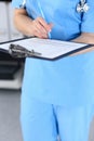 Female doctor filling up medical form on clipboard, closeup. Physician finishing up examining his patient in hospita Royalty Free Stock Photo