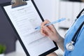 Female doctor filling up medical form on clipboard, closeup. Physician finishing up examining his patient in hospita Royalty Free Stock Photo