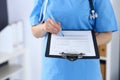 Female doctor filling up medical form on clipboard, closeup. Physician finishing up examining his patient in hospita Royalty Free Stock Photo