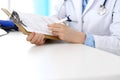 Female doctor filling up medical form on clipboard closeup. Physician finishing up examining his patient in hospital an Royalty Free Stock Photo