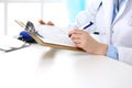 Female doctor filling up medical form on clipboard closeup. Physician finishing up examining his patient in hospital an Royalty Free Stock Photo