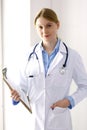 Female doctor filling up medical form on clipboard closeup. Physician finishing up examining his patient in hospital an Royalty Free Stock Photo