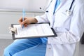 Female doctor filling up medical form on clipboard closeup. Physician finishing up examining his patient in hospital an Royalty Free Stock Photo