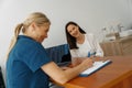 Smiling doctor fills out the medical report form on medical care of patients during appointment Royalty Free Stock Photo
