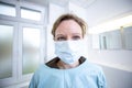 Female doctor in full protected medical suit holds a mouthpiece